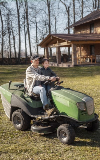 full-shot-smiley-man-driving-lawn-mower